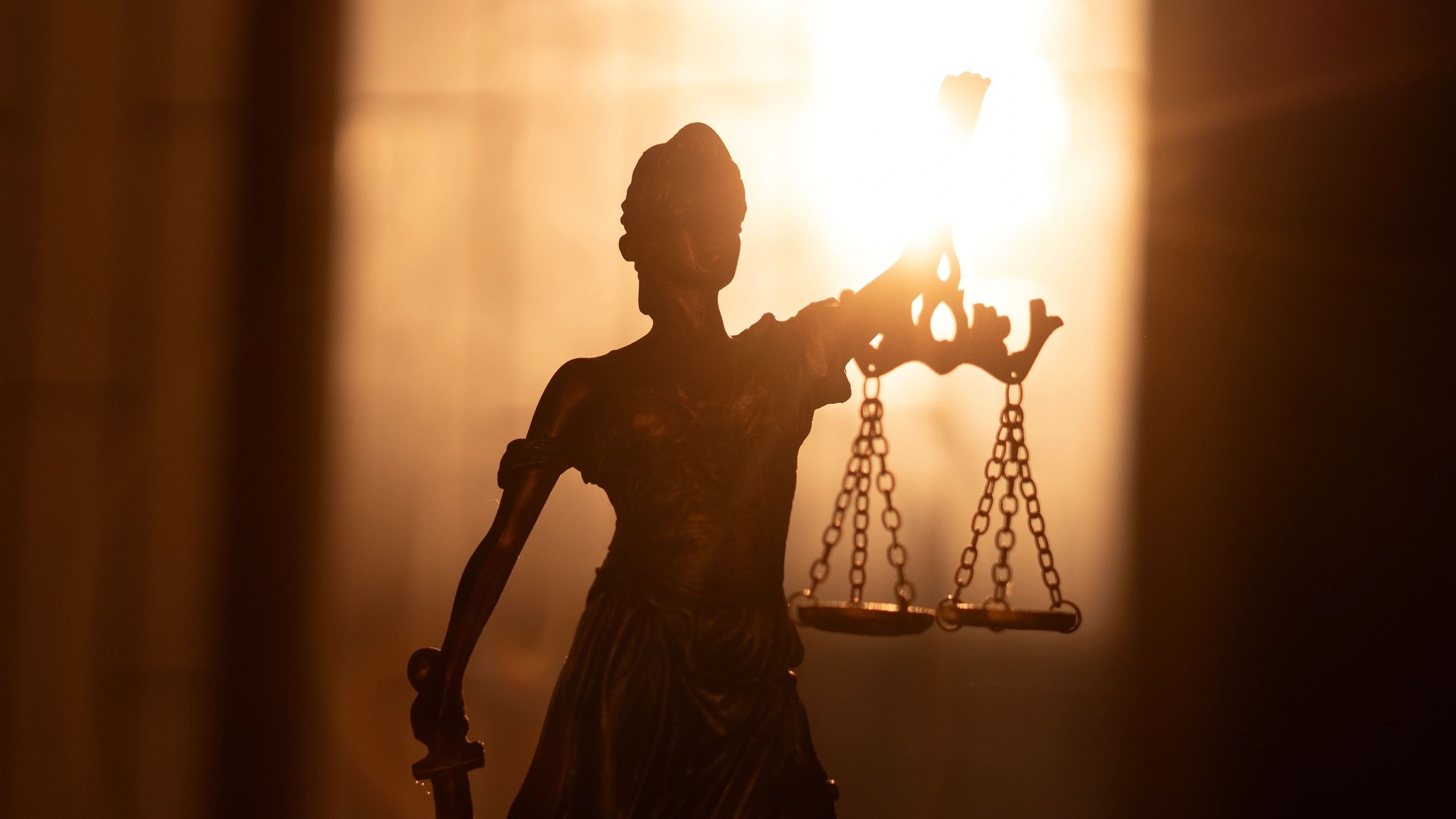 Estatua de la justicia con luz dorada
